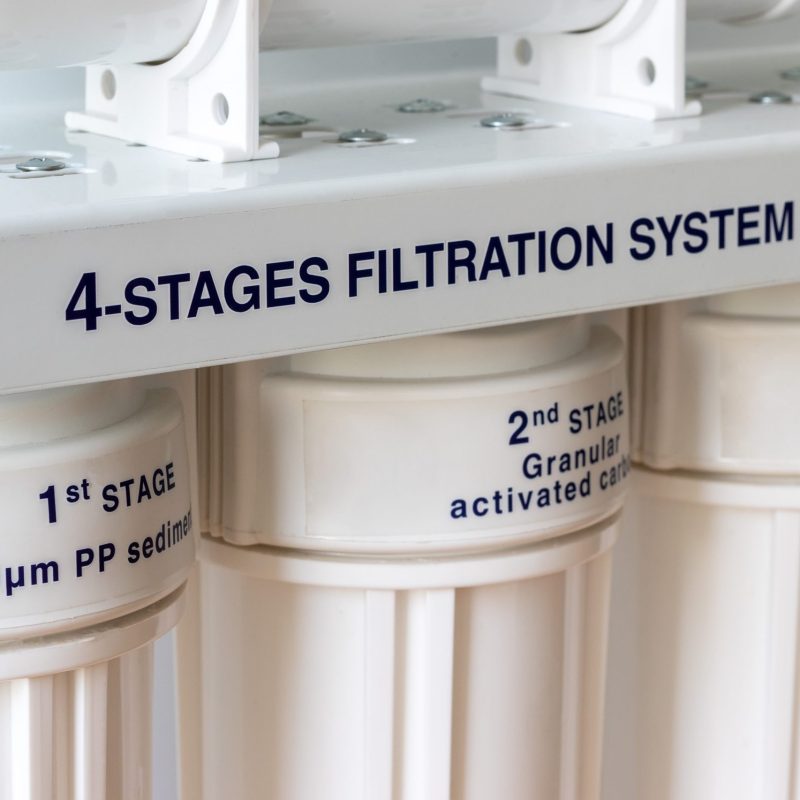 Four stages water filtration system for the home with granular activated and block carbon filters. Reverse osmosis system. Closeup view